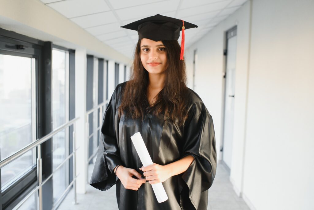 an indian graduate standing in the hallway